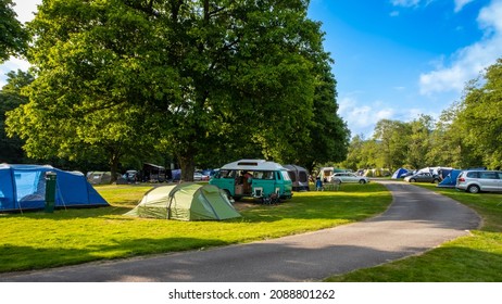 Camper vans and tents pitched at Cobleland Campsite during the summer in Trossachs National Park, Scotland