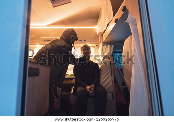 campervan\
caravan vehicle for van life holiday on camper van journey camping\
in mountains near the forest in the winter adventure season.\
snowing on the camper outdoor nomad\
lifestyle