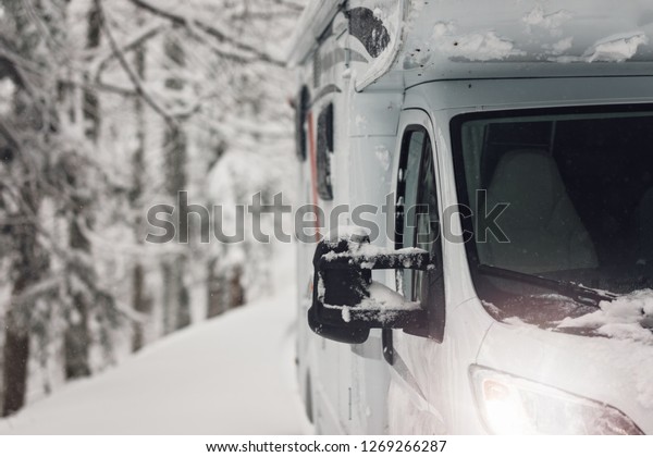 campervan
caravan vehicle for van life holiday on camper van journey camping
in mountains near the forest in the winter adventure season.
snowing on the camper outdoor nomad
lifestyle