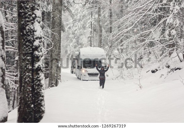 campervan\
caravan vehicle for van life holiday on camper van journey camping\
in mountains near the forest in the winter adventure season.\
snowing on the camper outdoor nomad\
lifestyle
