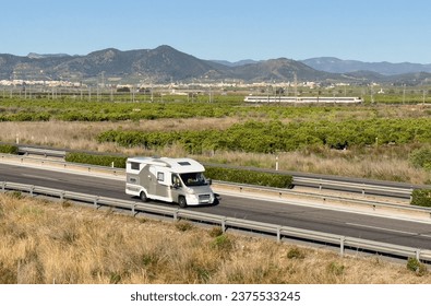 Campervan drive on highway. Family camper van driving on motorway. Motorhome lifestyle travel to sea and mountains. Travel along Spain coast. Traffic cars on road.