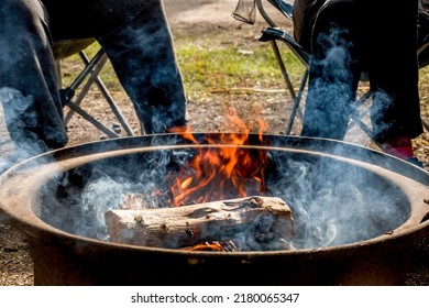 Campfire Burning In A Firepit . People Sitting Around. Camping Life. Outdoor Family Recreation.