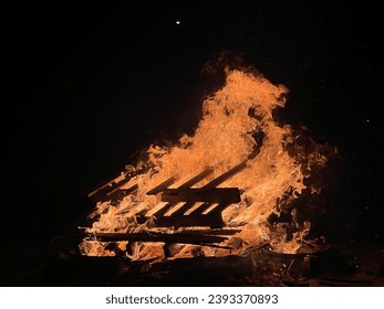 Una fogata en el camping que proporciona luz, calor y calor para cocinar. Las fogatas son una característica popular del camping. Fondo oscuro visto con quema de pallete