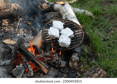 Campfire fire bbq grilling sausage cheese tin foil covered wrapped - Powered by Shutterstock