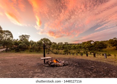 Campfire With Fire Burning In A Campground In The Australian Outback And A Beautiful Sunset Sky Overhead.