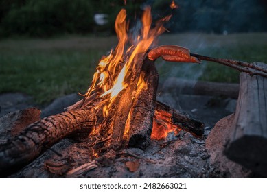 campfire on a campfire, in the bosom of nature and a sausage roasted over a campfire - Powered by Shutterstock