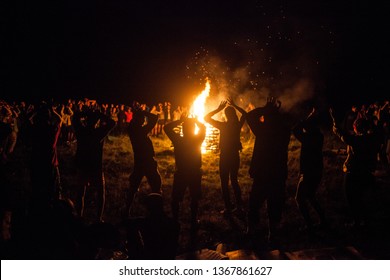 Campfire With Sparks. Group Of People Dance Around Big Bonfire And Sing At The Night. Party After Active Day. Travel And Vacation. Great Connection To Nature Concept