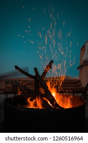 Campfire at touristic camp at nature in mountains. Flame and fire sparks on dark blue background. Hellish fire element. Fuel, power and energy Burning wood at night in desert of Palestine, Jerusalem