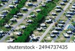 Campground office in large RV park campsite with long row of recreational vehicles and trailers boats tall palm trees in South Padre Island, aerial view campers basecamp with power hookup, Texas. USA