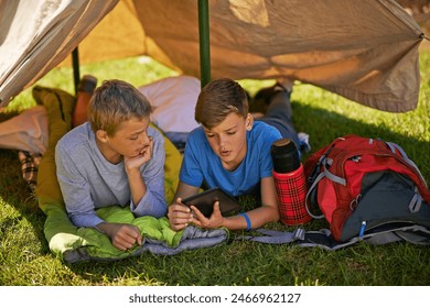 Camping, adventure and kids in tent with tablet for outdoor activity, friends on vacation in park. Children, boys and freedom in nature with ebook for social media, online network with news in Europe - Powered by Shutterstock