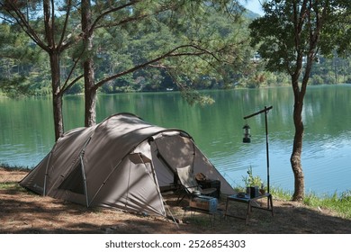 Camping alone, solo camper, Relax and enjoy in the nature. Royalty high-quality free best stock of Tent on the tranquil lake in a pine forest. Peaceful, quiet, beautiful landscape, Enjoying adventure - Powered by Shutterstock