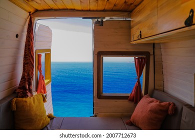 Camping in a campervan. Calm and beautiful blue seascape in the background. Wild camping concept. Caravan interior design. - Powered by Shutterstock