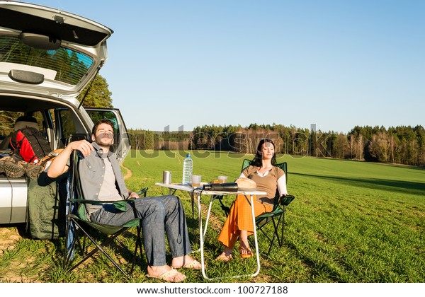 Camping car happy couple enjoy sun relax\
picnic in countryside