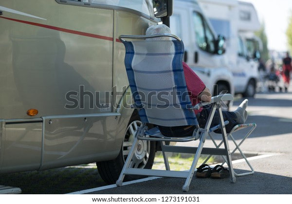 camping chair in the\
shadow of a camper