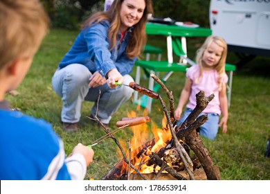 Camping: Family Cooking Hot Dog Over Campfire