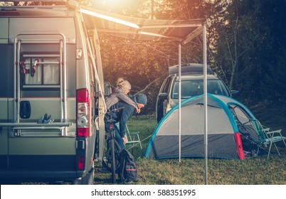 Camping Family Time. Father Playing With His Daughter Around Camper Van RV And Tents. Family On The Campground.