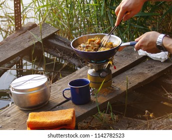 Camping food making. Pasta on pan on tourist fire stove. Camp cooking on the shore of the lake. - Powered by Shutterstock