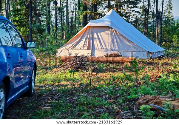 Camping in the\
forest with car parked\
nearby