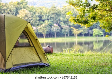 Camping green tent in forest near lake - Shutterstock ID 657542155