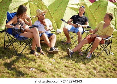 Camping, group of friends in conversation at tent and relax with outdoor chat, drinks and grass. Nature, men and woman at campsite together for music festival, adventure and people bonding in park. - Powered by Shutterstock