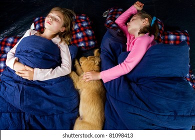 Camping Kids And A Puppy Sleeping In A Tent.