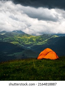 Camping in the mountains with tent standing on a hill, night and sunset landscape