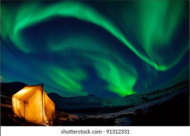 Camping in the north with the northern lights overhead (Aurora Borealis)