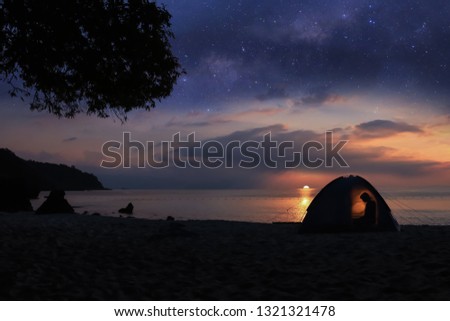 Camping on the beach with million stars galaxy , shadow of a woman in the tents from morning sun.At ang thong island