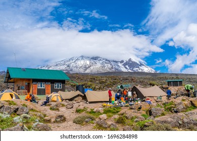 Camping on mount Kilimanjaro in tents to see the glaciers in Tanzania, Africa Orange tents on the way to Uhuru Peak.