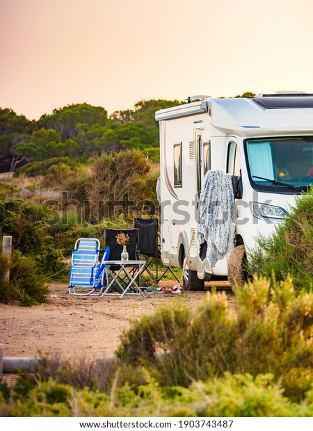 Camping on sea shore. Camper vehicle on beach,\
mediterranean coast in\
Spain.