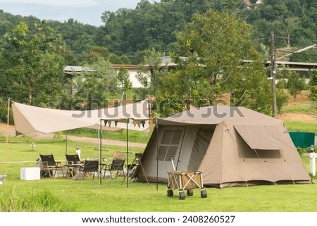 Camping picnic green tent campground in outdoor park lake. Camper while campsite in mountain and lake nature background at summer trip camp. Adventure Travel and Vacation concept