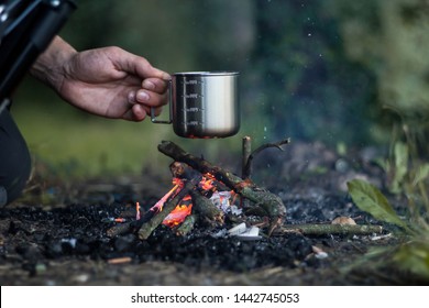 Camping survival cooking outdoors fire tin cup pot coals summer hiking survivalist adventure  - Powered by Shutterstock