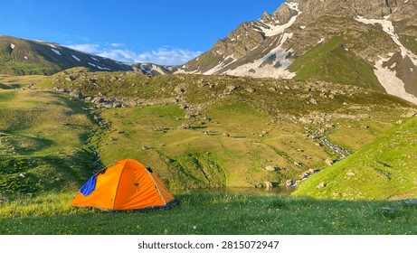 Camping tent forms an overnight base beside Green Abudelauri Lake in Georgia, presenting backcountry shelter, expedition equipment and self-supported trekking in the remote Caucasus highlands.