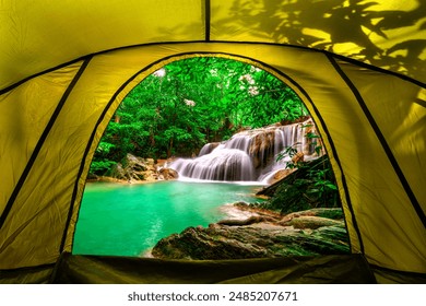 camping tent, looking inside the tent to view the emerald blue water in Erawan National Park. Erawan Waterfall is a beautiful natural rock waterfall in Kanchanaburi, Thailand.