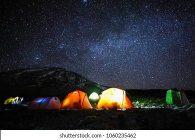 Camping in tents on mount Kilimanjaro at night with stars in sky to see the glaciers at the summit, Africa