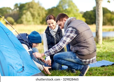 Camping, Tourism, Hike, Family And People Concept - Happy Parents And Son Setting Up Tent Outdoors