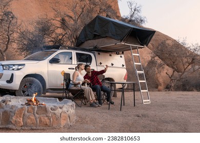 camping, tourism and travel concept - happy couple with smartphone taking selfie at tent camp - Powered by Shutterstock