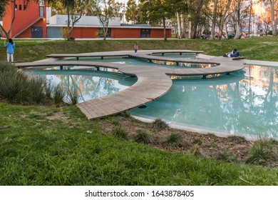 Campo Grande, Lisbon PORTUGAL - 3 February 2020 - Walking Around Cityscape At Mário Soares Garden, People Lifestyle On Wooden Walkway Over Artificial Lake Reflecting Surrounding Vegetation At Sunset