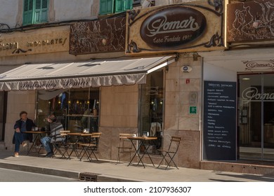 Campos, Spain; January 15 2022: Main Facade Of The Famous Mallorcan Pastry Shop Pomar, With Customers Wearing Mask. New Normal