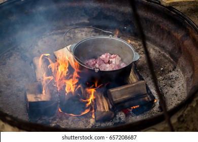 Campsite With A Dutch Oven Cooking Over A Fire Ring