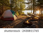 Campsite on lake in northern Minnesota with campfire at sunset