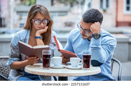 Campus life. Thoughtful young students sitting in a cafe, reading a books and preparing for the test. Education, relationships, love concept - Powered by Shutterstock