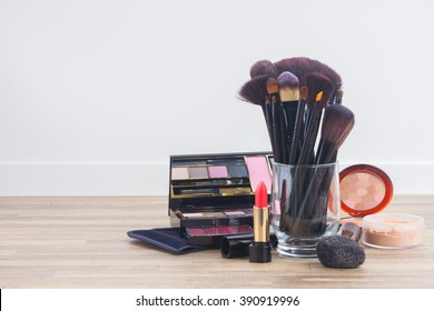 Can With  Brushes And Make Up Products On Wooden Table With Copy Space