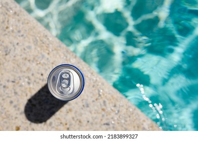 A Can Of Cold Drink By The Pool In A Hotel On A Hot Day. Top View, Selective Focus On The Bank.