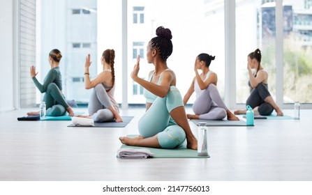 I can feel that in my spine. Full length shot of an unrecognisable woman leading a yoga class in her studio and holding a spinal twist pose. - Powered by Shutterstock