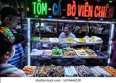 CAN THO, VIETNAM - AUGUST 11: Vietnamese man selling street food on night market in Mekong River Delta on August 11, 2018 in Can Tho, Vietnam.