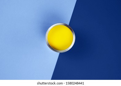 Can of yellow paint on a classic blue background. Arkivfotografi