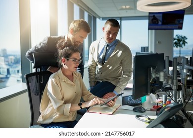 Can You Guys Come Take A Look At This Quickly. Shot Of A Group Of Young Businesspeople Working Together On A Computer Inside Of The Office During The Day.