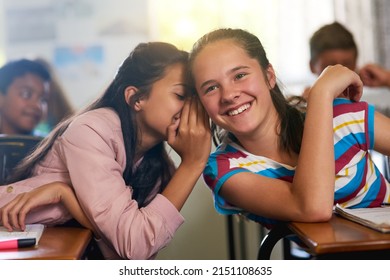 Can you keep a secret. Shot of a young schoolgirl whispering a secret to her friend in class. - Powered by Shutterstock