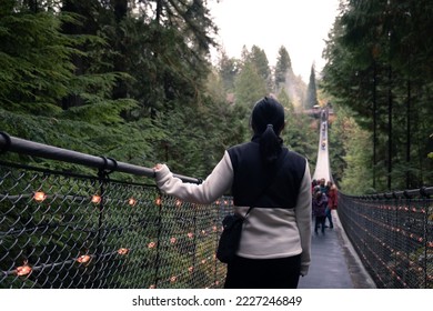 Canada Autumn travel destination in British Columbia. Tourists walking in famous attraction Capilano Suspension Bridge Park in North Vancouver, Canadian vacation for tourism.